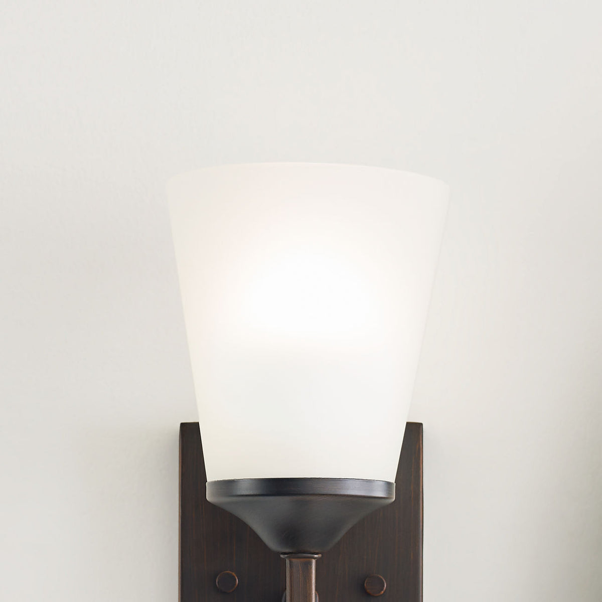 Generation Lighting Hanford 1 light bath wall light in dark finish with etched glass