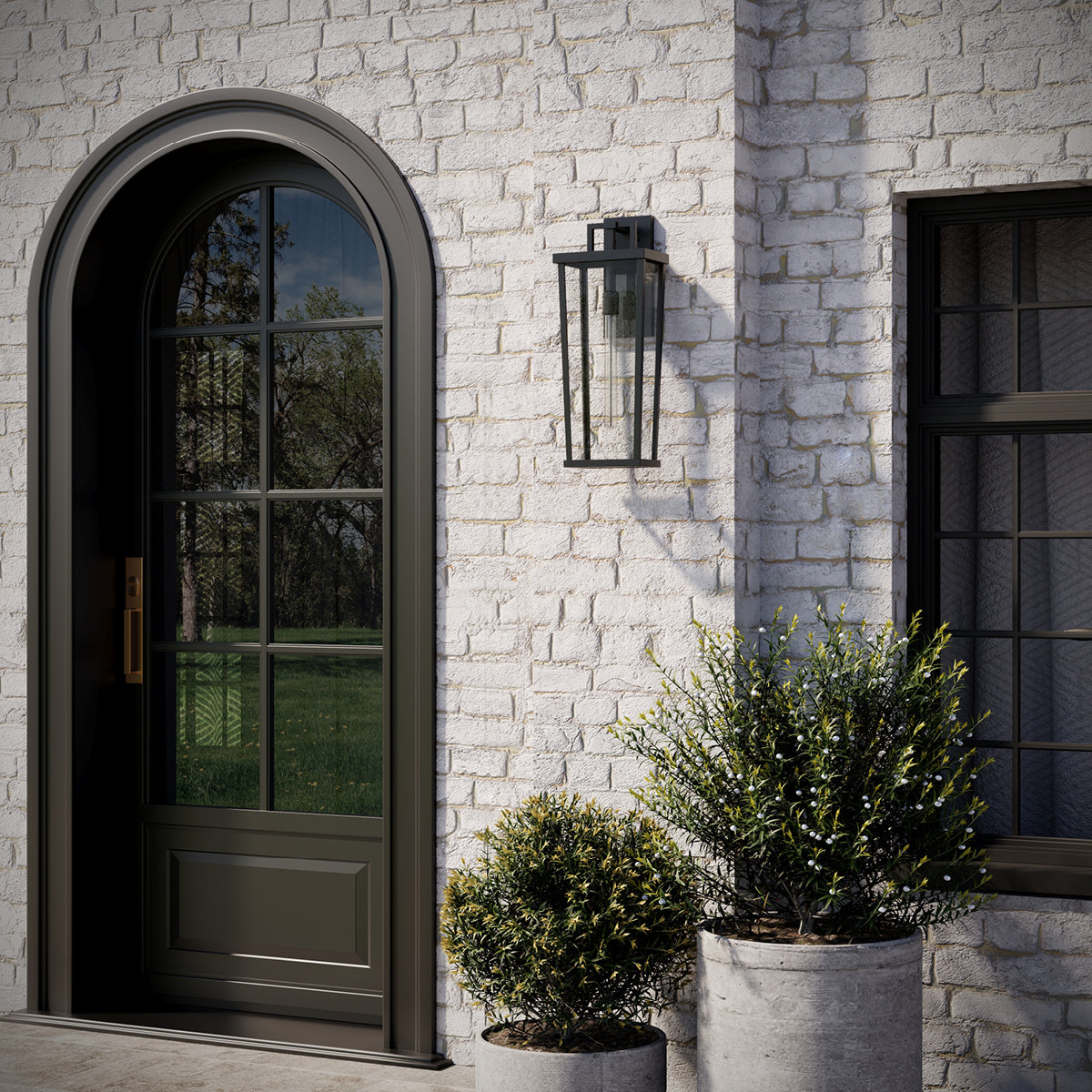 Tryon black outdoor wall lantern installed beside entry door in daylight
