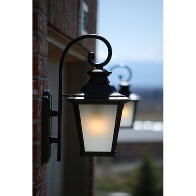 Maxim Lighting 1125FSBZ Knoxville Bronze Outdoor Wall Lantern illuminated at dusk on brick wall