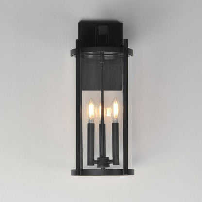 Maxim Lighting 30065CLBK Belfry 3 Light Black Outdoor Wall Sconce Mounted on Grey Wall Showing All Three Candelabra Bulbs Lit