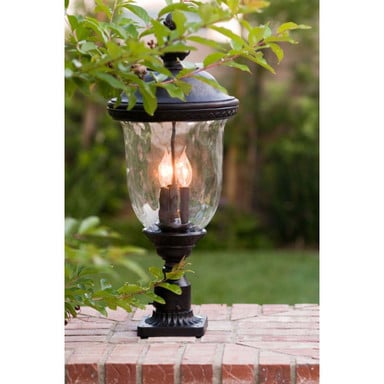 Maxim Lighting 3421WGOB Carriage House DC Outdoor Post Light close-up on brick surface with greenery