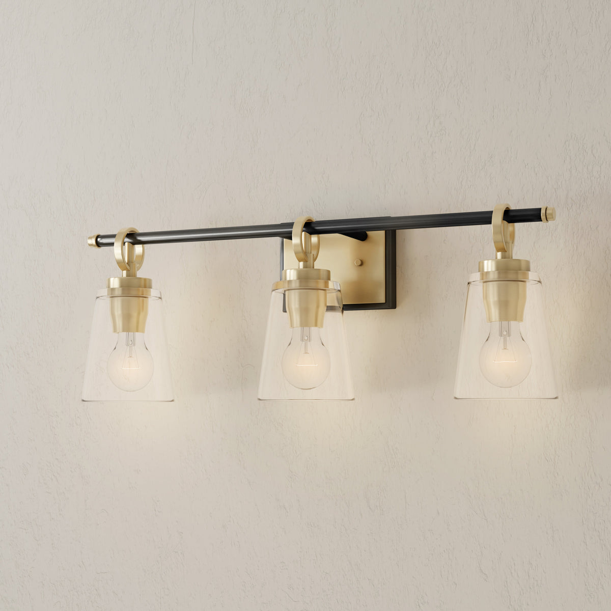 Progress Lighting Cassell 3 light bath vanity wall light illuminated in Vintage Brass